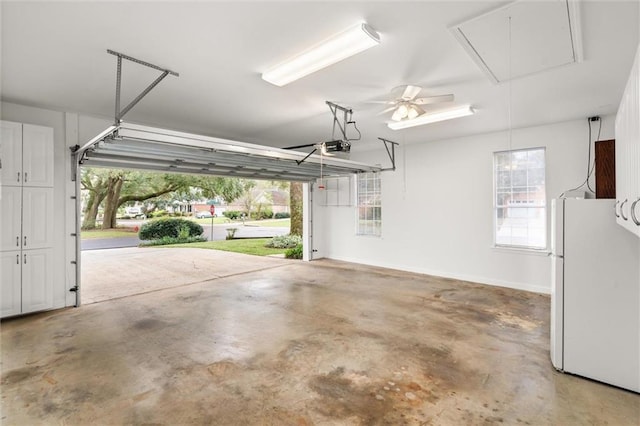 garage featuring white fridge, a garage door opener, and ceiling fan