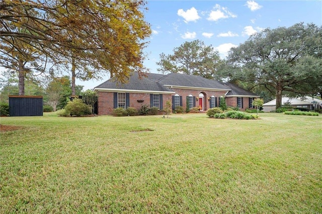 ranch-style home featuring a front lawn and a storage unit