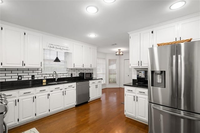 kitchen featuring stainless steel appliances, white cabinetry, plenty of natural light, and sink