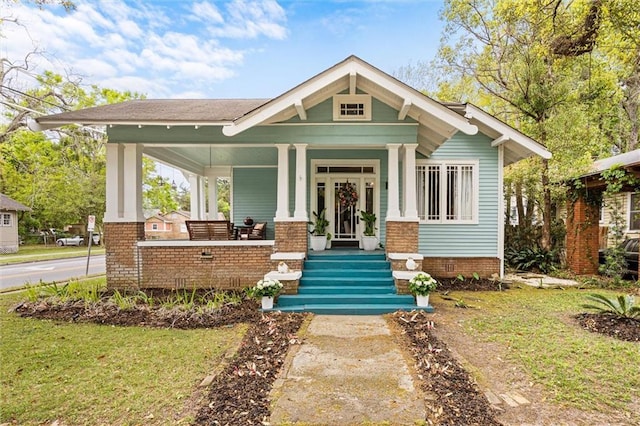 craftsman-style home with a front lawn and a porch