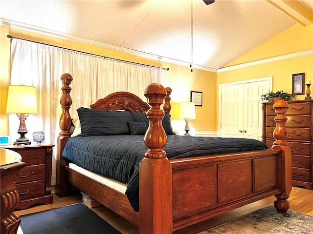 bedroom featuring ornamental molding, ceiling fan, lofted ceiling with beams, hardwood / wood-style floors, and a closet