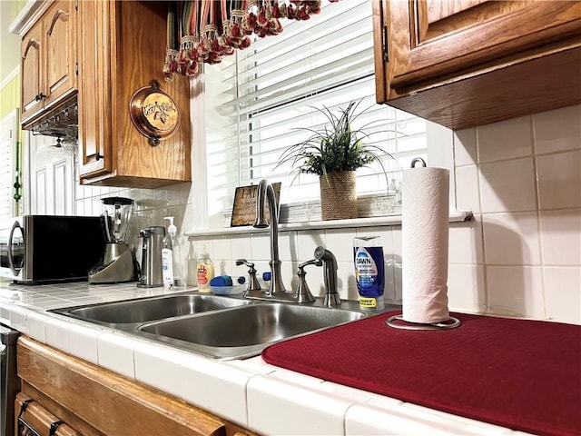 kitchen featuring tasteful backsplash, tile counters, and sink