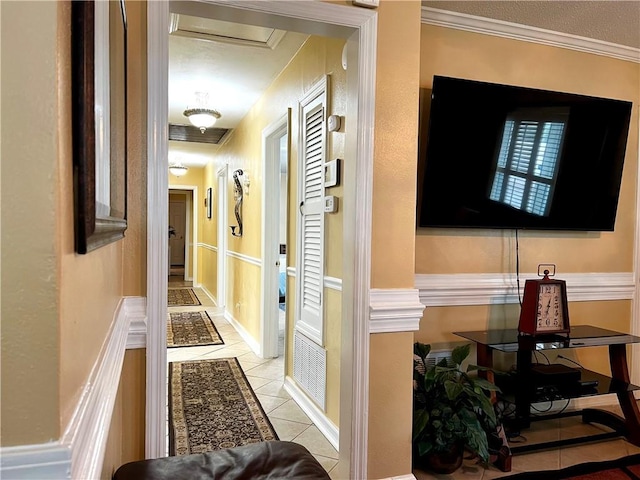 hall featuring crown molding and light tile patterned floors