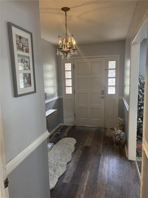 1205 Cadiz St, Mobile, AL 36693 - entrance foyer featuring a textured ceiling, baseboards, a notable chandelier, and dark wood-style floors