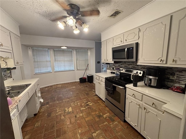 1205 Cadiz St, Mobile, AL 36693 - kitchen featuring ceiling fan, light countertops, stainless steel appliances, tasteful backsplash, and visible vents