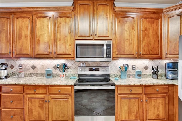 kitchen featuring stainless steel appliances, light stone counters, and tasteful backsplash