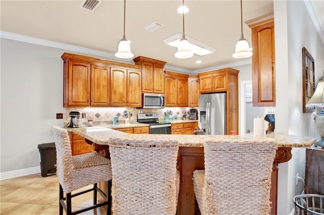 kitchen featuring kitchen peninsula, appliances with stainless steel finishes, a breakfast bar area, decorative light fixtures, and crown molding