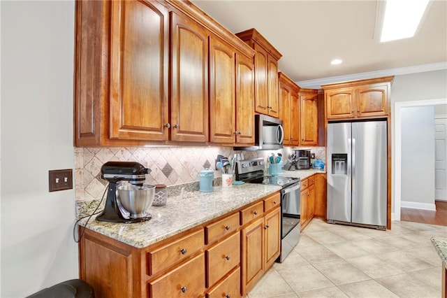 kitchen featuring stainless steel appliances, light stone countertops, ornamental molding, and tasteful backsplash