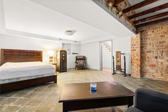 bedroom featuring tile patterned floors and brick wall