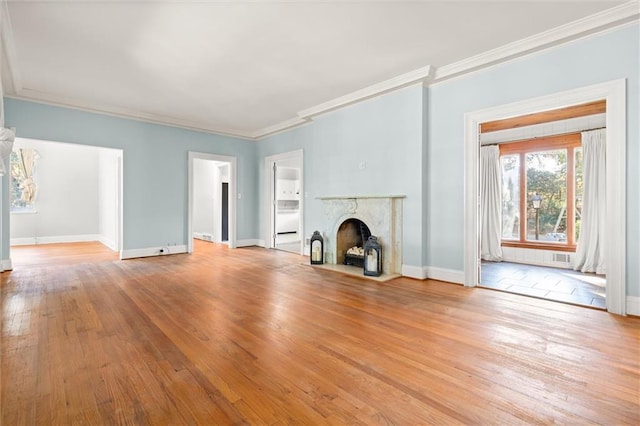 unfurnished living room with crown molding, light hardwood / wood-style flooring, and a high end fireplace