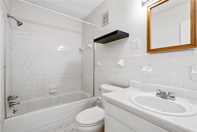 full bathroom with tile walls, decorative backsplash, tiled shower / bath, vanity, and toilet