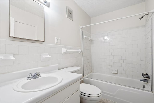 full bathroom featuring vanity, tiled shower / bath combo, tasteful backsplash, a textured ceiling, and toilet