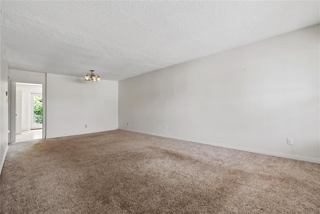 carpeted spare room with a textured ceiling