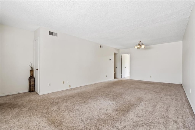 spare room with carpet and a textured ceiling