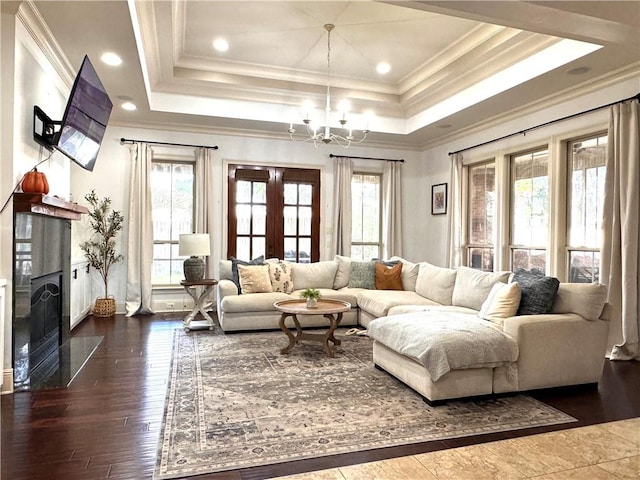 living room with an inviting chandelier, ornamental molding, dark hardwood / wood-style floors, and plenty of natural light