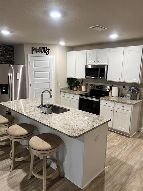 6157 Stream Bank Dr, Mobile, AL 36582 - kitchen with a sink, light stone countertops, light wood-type flooring, and stainless steel appliances