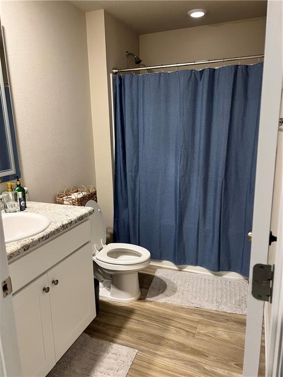 6157 Stream Bank Dr, Mobile, AL 36582 - bathroom featuring curtained shower, vanity, toilet, and wood finished floors