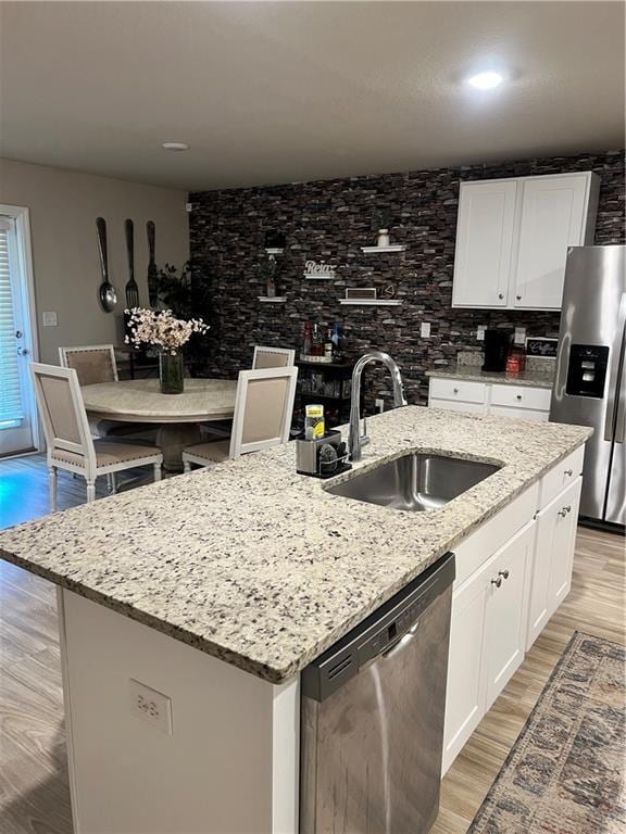6157 Stream Bank Dr, Mobile, AL 36582 - kitchen with a sink, light wood-type flooring, white cabinetry, a center island with sink, and stainless steel appliances