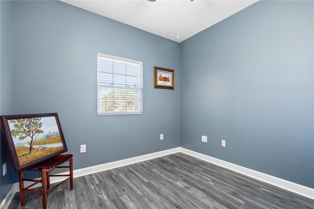 living area with dark wood-style floors, ceiling fan, and baseboards