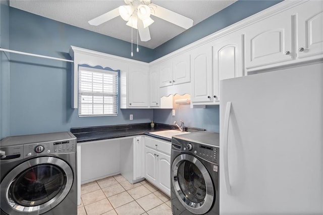 laundry room with washing machine and clothes dryer, light tile patterned floors, cabinet space, ceiling fan, and a sink