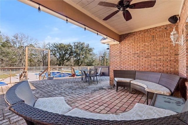 view of patio with ceiling fan, outdoor dining area, fence, and a pool