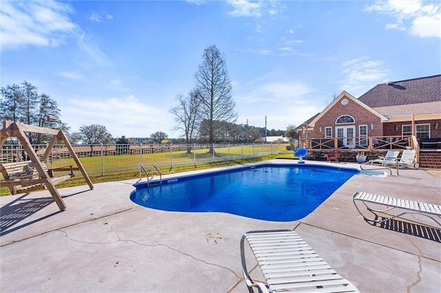 view of pool with a fenced in pool, french doors, a patio, fence, and a yard