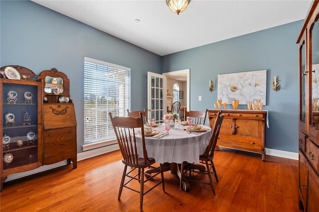 dining area with baseboards and wood finished floors