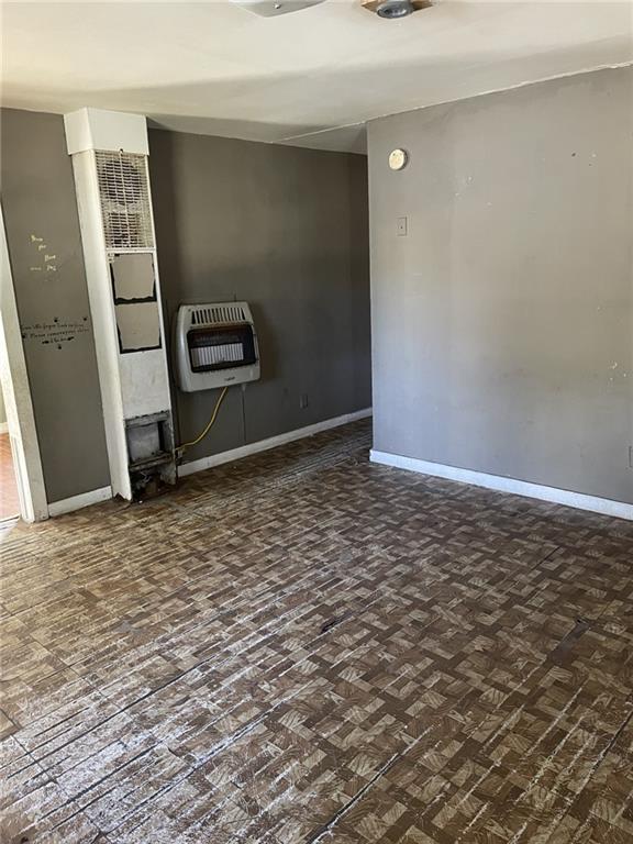 unfurnished room with heating unit