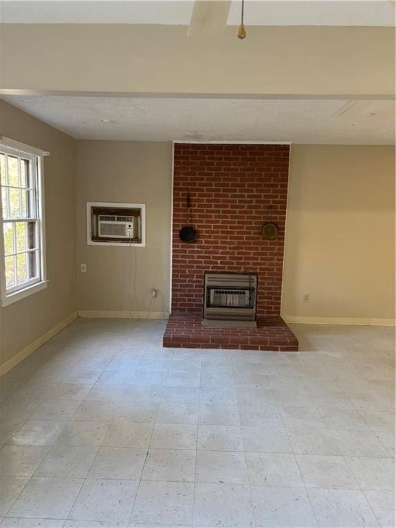 unfurnished living room featuring an AC wall unit and a brick fireplace