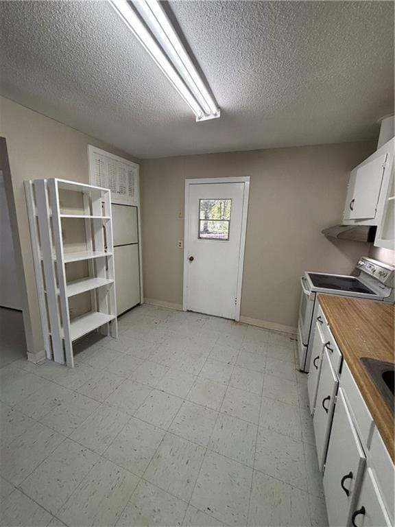 kitchen with electric stove, white cabinets, and a textured ceiling