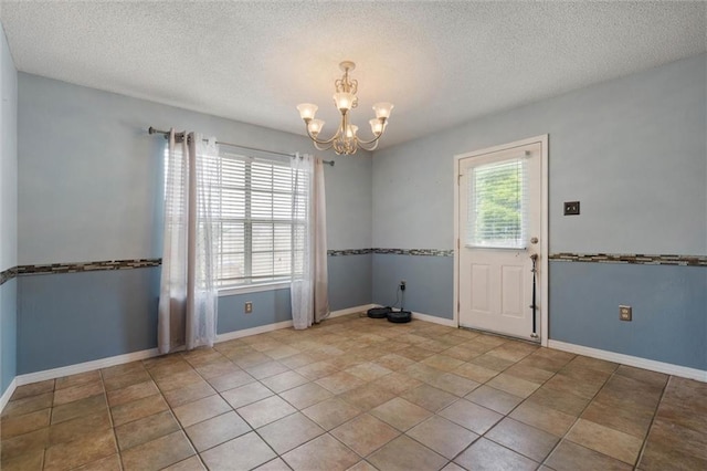3660 Ching Dairy Rd, Mobile, AL 36618 - unfurnished room featuring a chandelier, a textured ceiling, baseboards, and tile patterned flooring