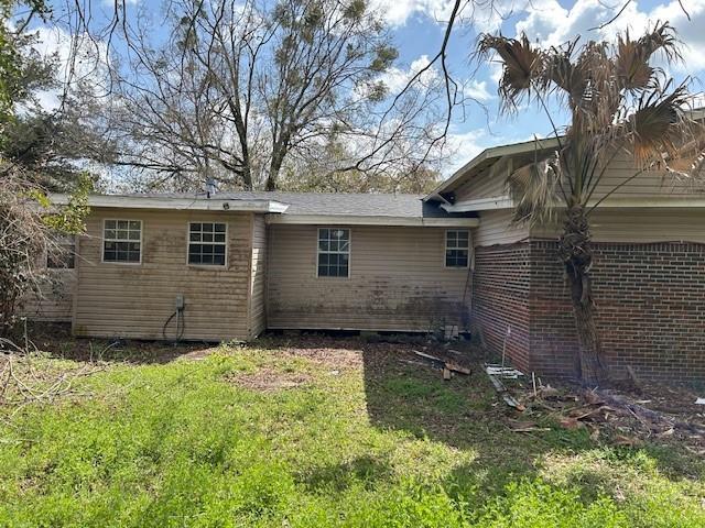 rear view of property featuring a lawn