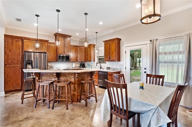 kitchen with a breakfast bar, sink, hanging light fixtures, a kitchen island, and stainless steel appliances