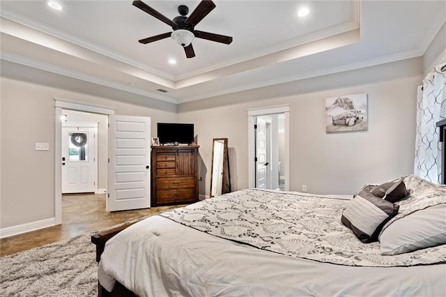 bedroom featuring ceiling fan, ornamental molding, and a tray ceiling