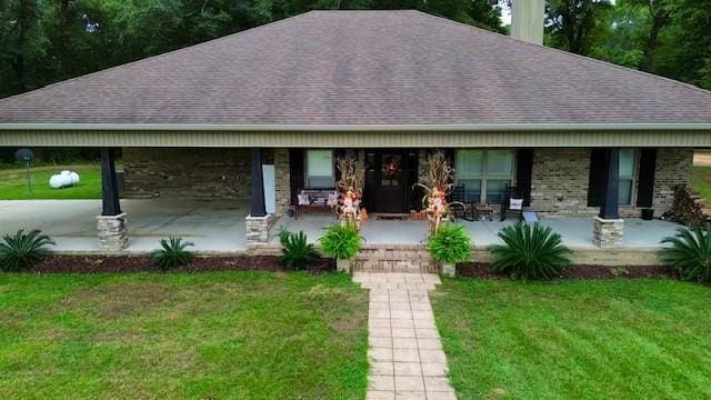 ranch-style house featuring a porch and a front lawn