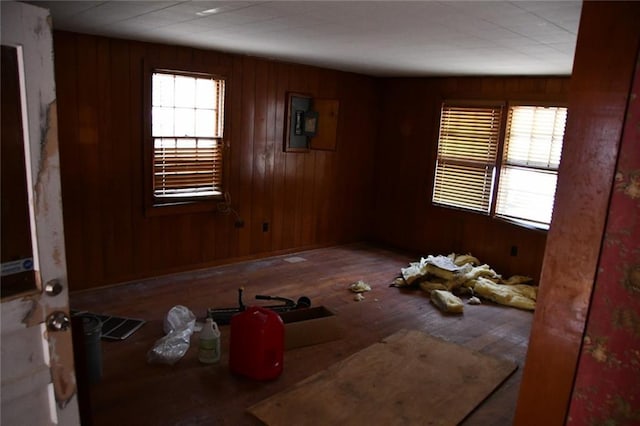 unfurnished room featuring hardwood / wood-style floors, a wealth of natural light, and wooden walls