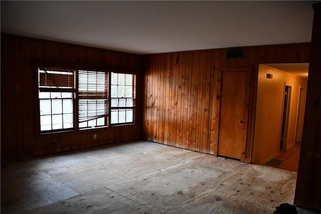 spare room featuring wooden walls