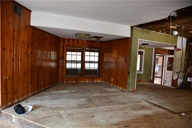 spare room with french doors and wooden walls