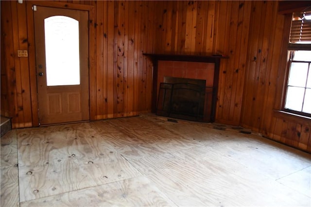 unfurnished living room with wood walls