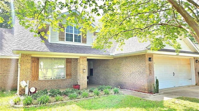 view of front of home featuring roof with shingles, an attached garage, concrete driveway, and brick siding