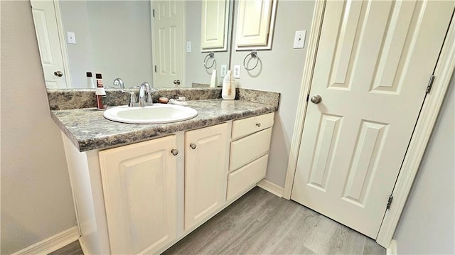bathroom with vanity, baseboards, and wood finished floors