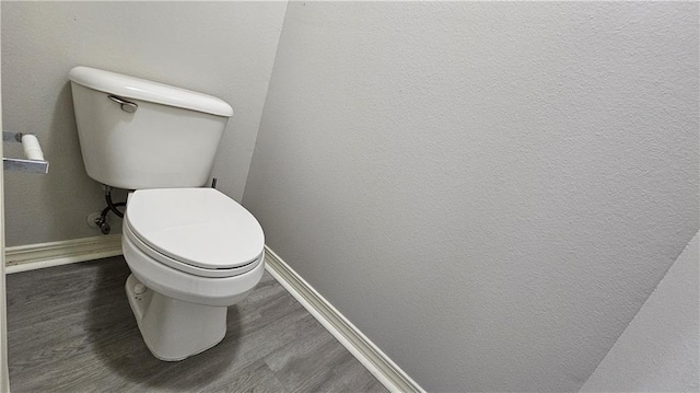 bathroom featuring toilet and baseboards