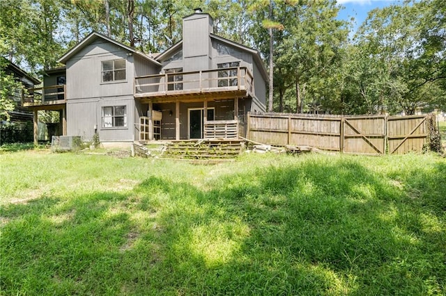 back of property with a wooden deck and a yard