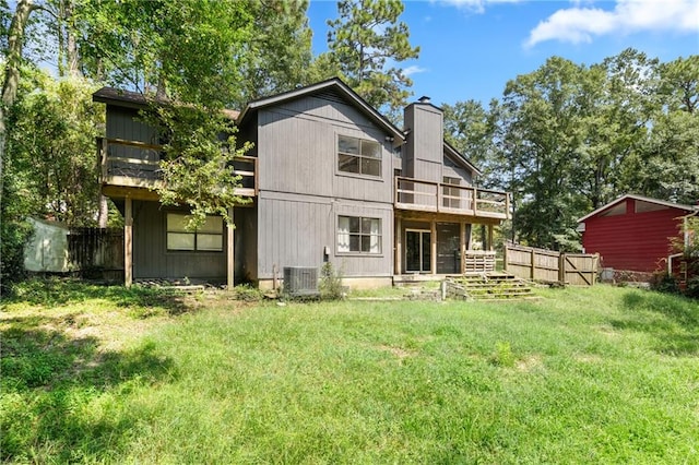 rear view of house featuring cooling unit, a lawn, and a balcony