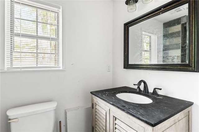 bathroom with vanity, toilet, and a wealth of natural light