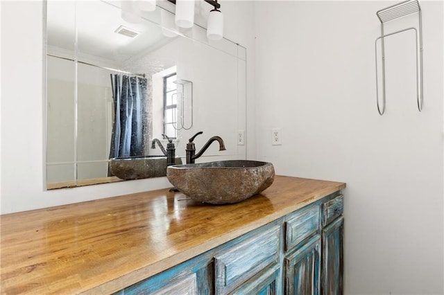 bathroom featuring vanity and a shower with shower curtain