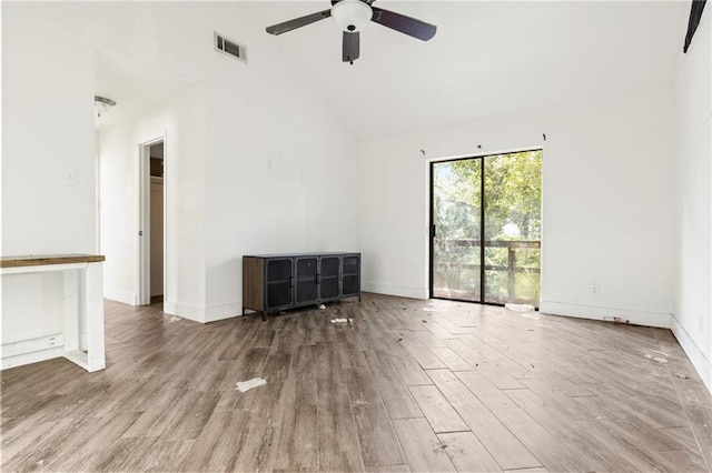 empty room with high vaulted ceiling, ceiling fan, and wood-type flooring