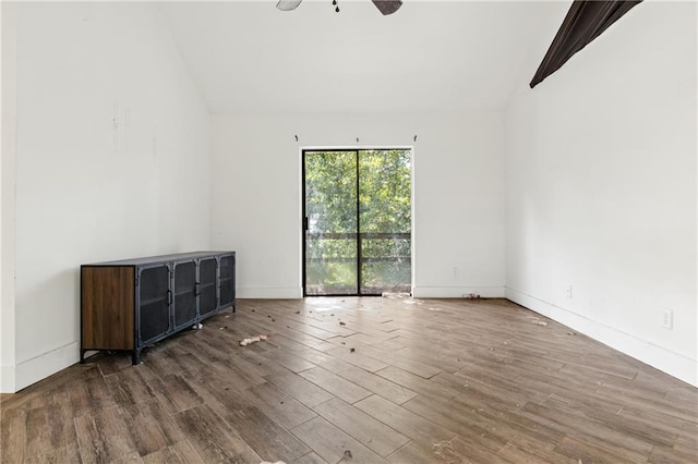 unfurnished room with ceiling fan, hardwood / wood-style flooring, and vaulted ceiling