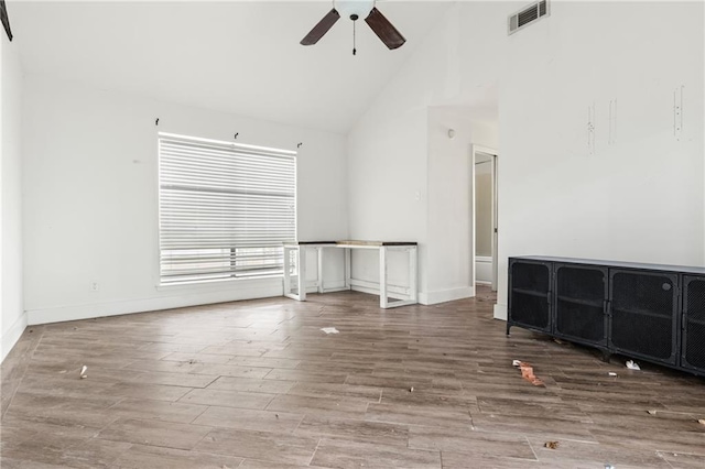 unfurnished living room featuring wood-type flooring, ceiling fan, and high vaulted ceiling