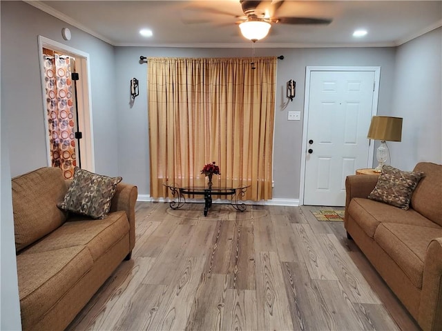 living room with hardwood / wood-style flooring, ceiling fan, and crown molding